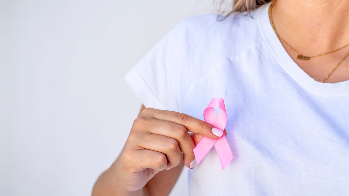 Close up of woman showing pink ribbon symbolizing breast cancer