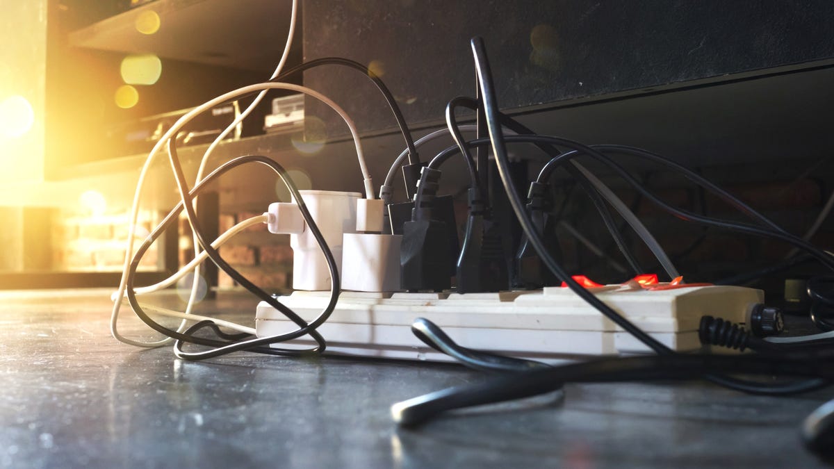 A power strip with many plugs sits on a floor.