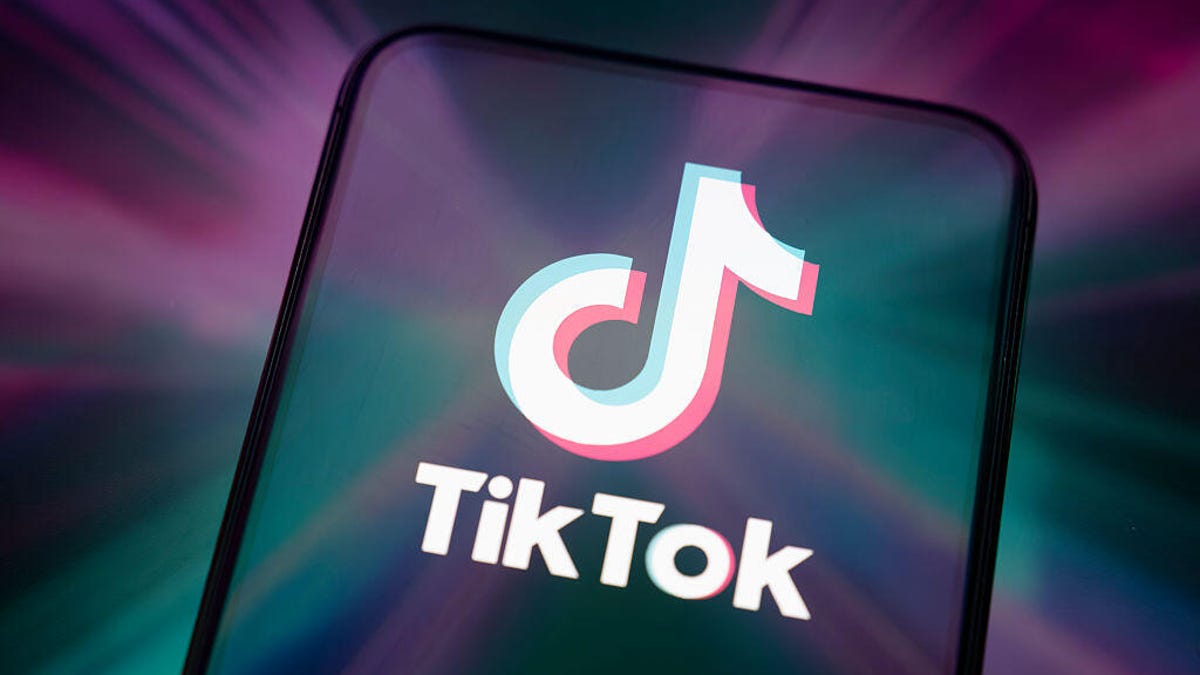TikTok logo on phone with purple and green lights