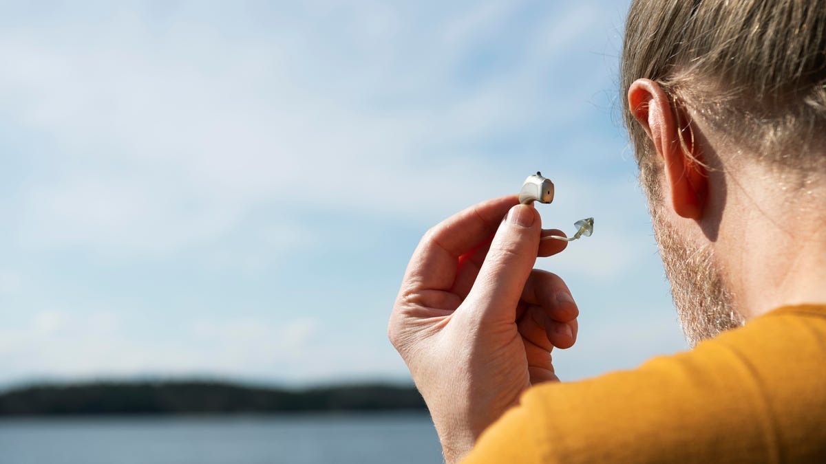 A man holding a hearing aid