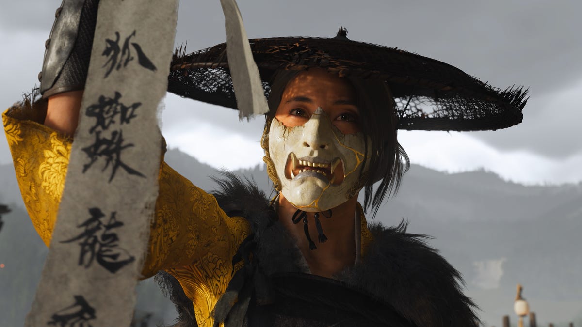 Atsu in her samurai armor holds up a parchment with Japanese text on it.