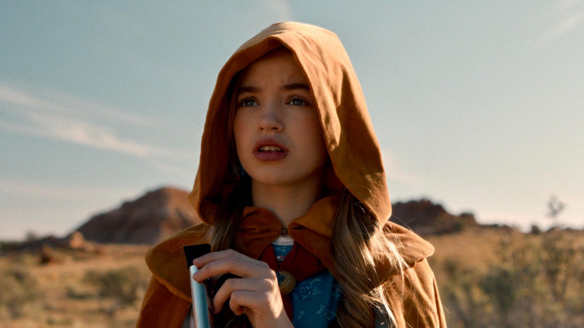 Stranger Things character with brown hood against a mountain background