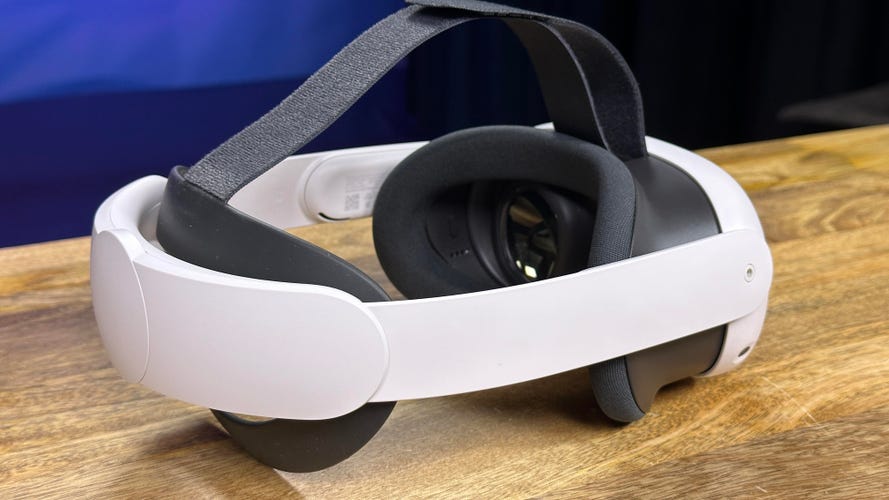 A VR headset with plastic head strap on a wooden table