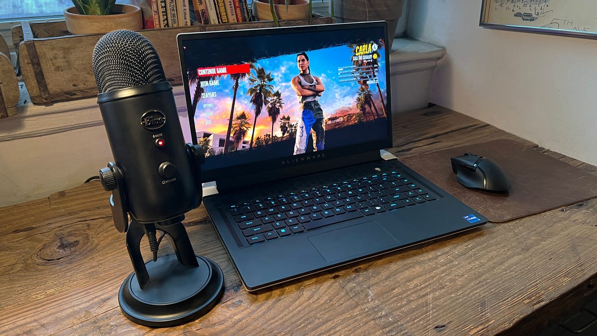 a podcast-style microphone next to a laptop showing Dead Island 2