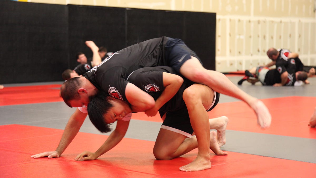 Reporter Alfred Ng tries to escape from a chokehold in a Brazilian jiujitsu match.