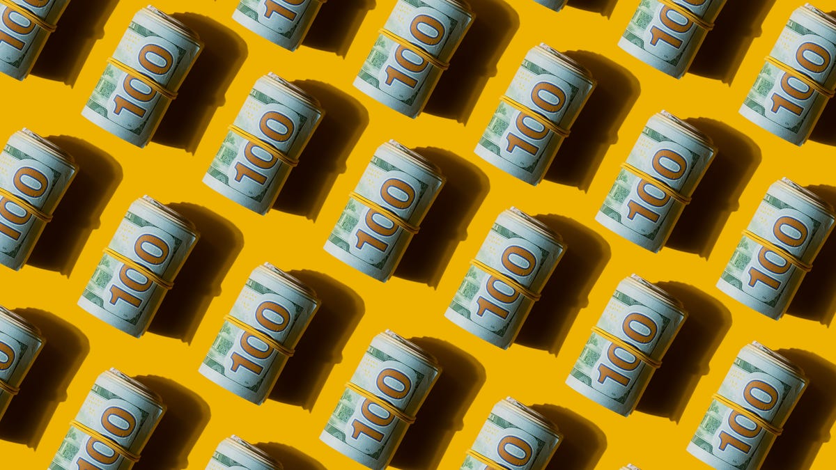 rolls of 100 dollar bills against a yellow background
