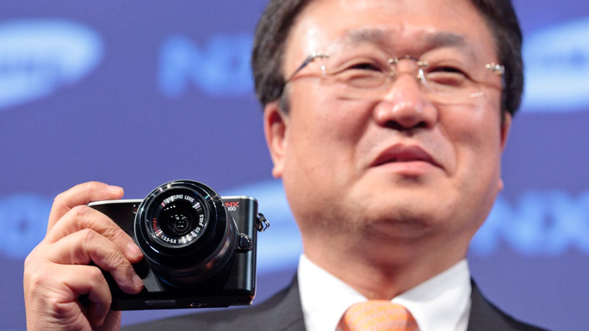 Sangjin Park, president of Samsung's digital imaging division, holds the NX100 at a press conference at the Photokina show in Cologne, Germany.