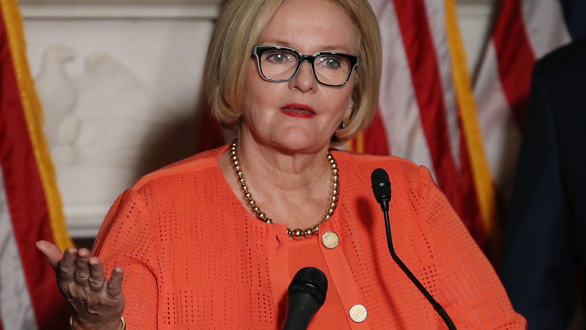 Sen. Claire McCaskill at a press conference, with right arm gesturing while she addresses the room.