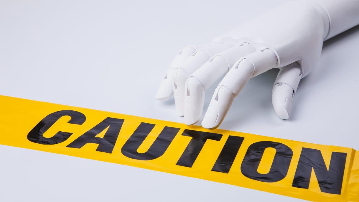 Photo-illustration showing a robotic hand fingering a bit of yellow caution tape that lies flat on a surface. It appears the hand and fingers could decide to "walk" across the tape.