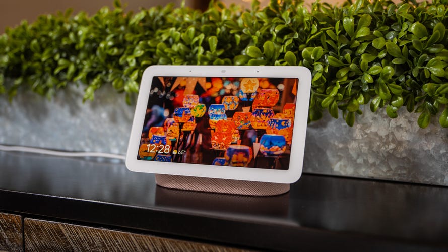 google nest hub 2nd gen sits on a ledge, displaying the time and a picture