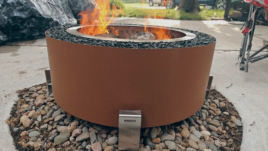 Breeo Luxeve smokeless fire pit with a fire sitting on a patio.