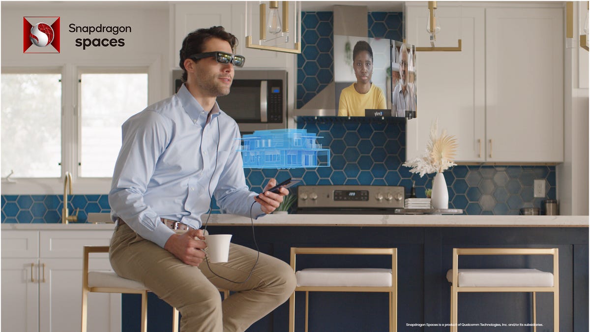 A man with AR glasses on, holding a phone, seeing a floating window with a person speaking to him