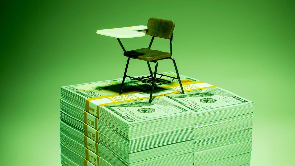 Student desk atop stacks of money
