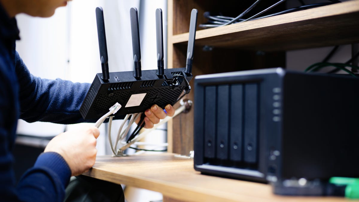 A person plugging in a router.