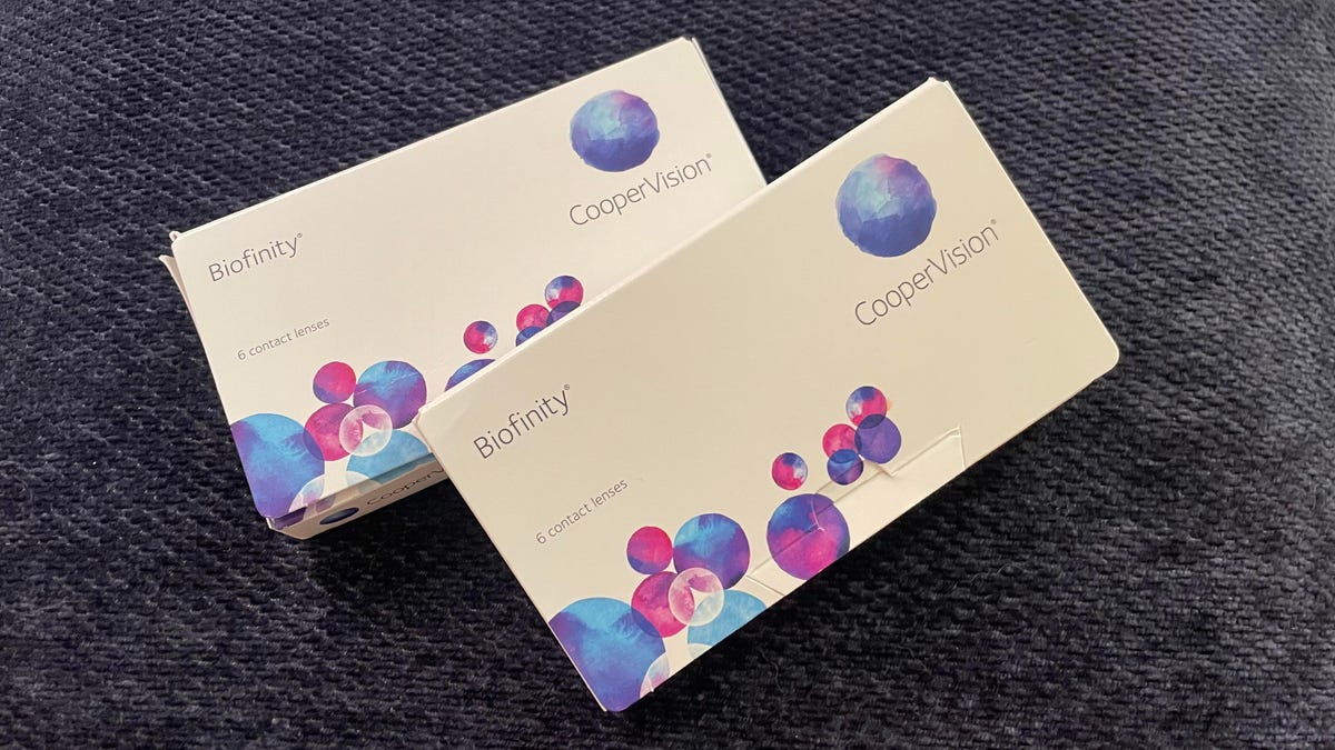 Two boxes of contacts on a blue pillow