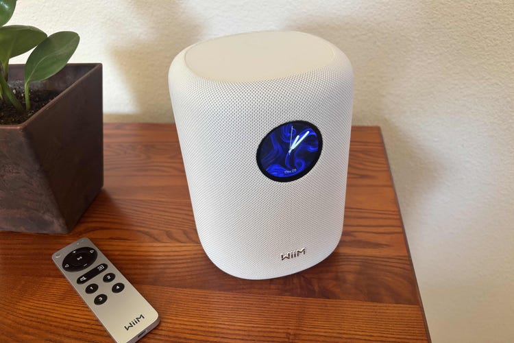 Wiim's Sound speaker on a wood table by a remote.
