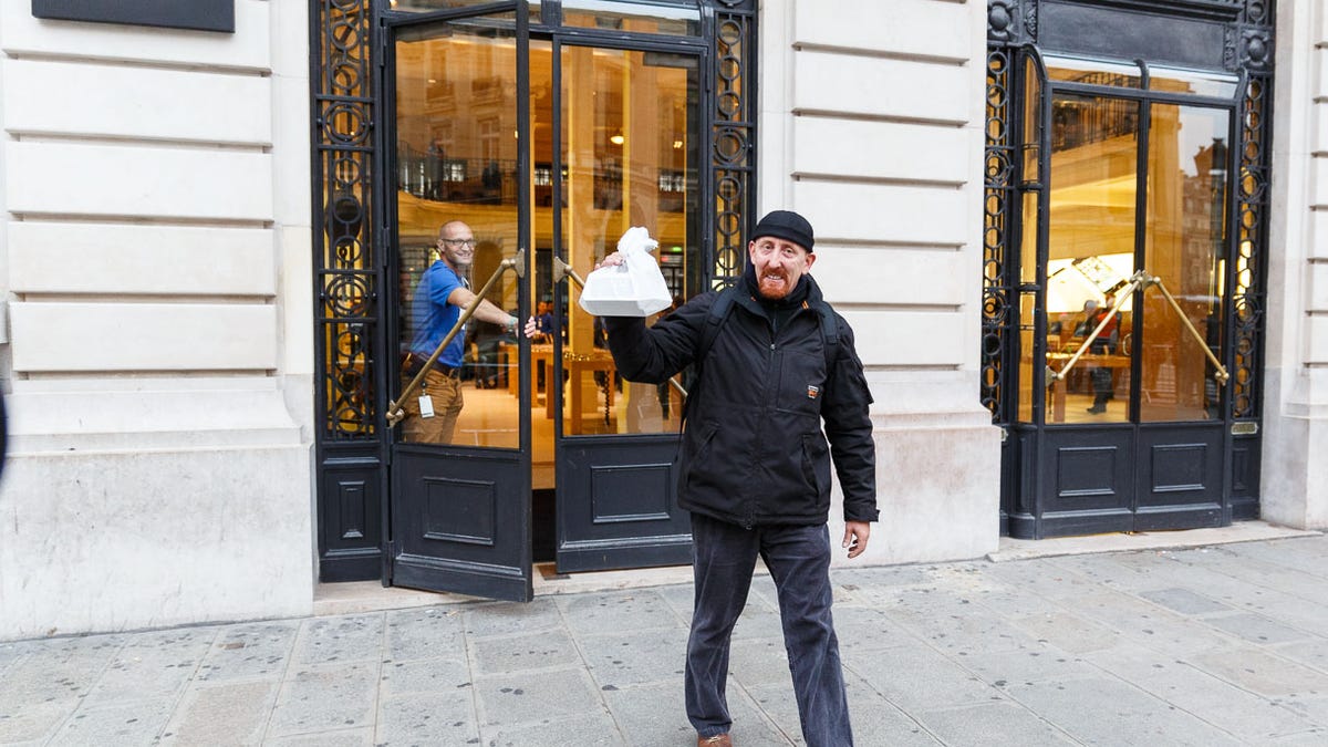 Sylvain Gautier emerges from the Apple store in Paris at 8:03 a.m. local time Friday after becoming the first in France to buy an iPhone 5S, Apple's new flagship smartphone.