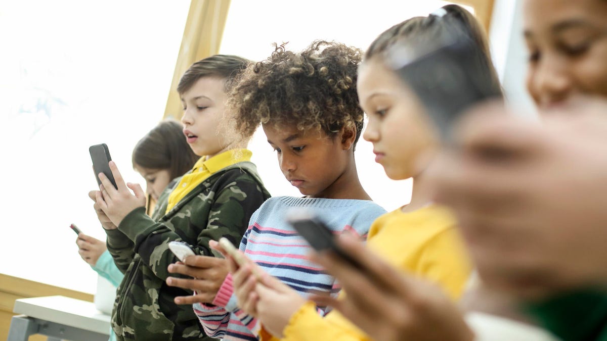 A row of children using mobile phones