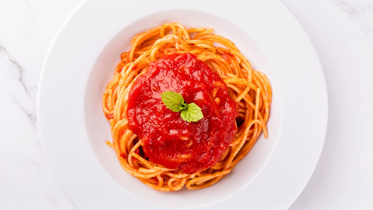 Spaghetti with tomato sauce on white background