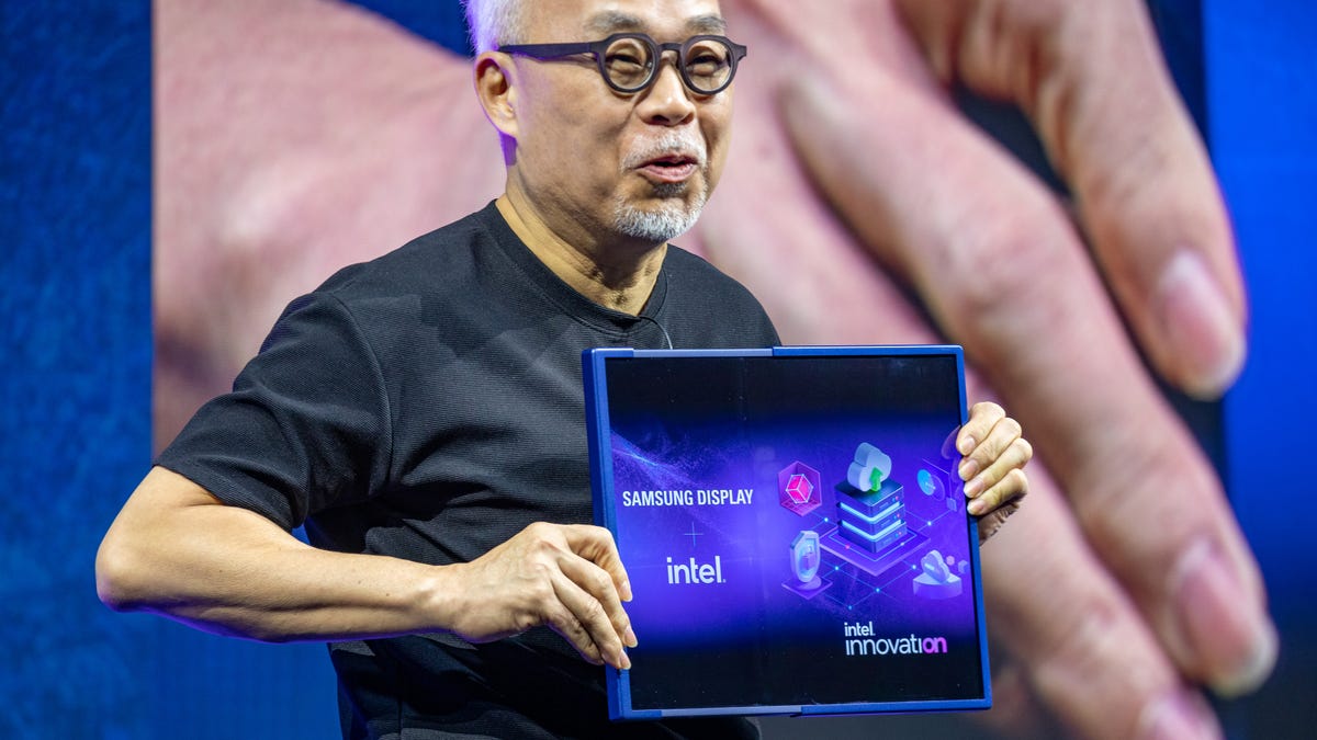 JS Choi, leader of Samsung's display division, pulls the edge of a laptop-sized "slidable" screen to extend its width