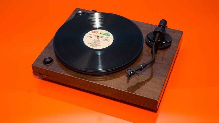 The Fluance RT82 turntable on an orange background. 