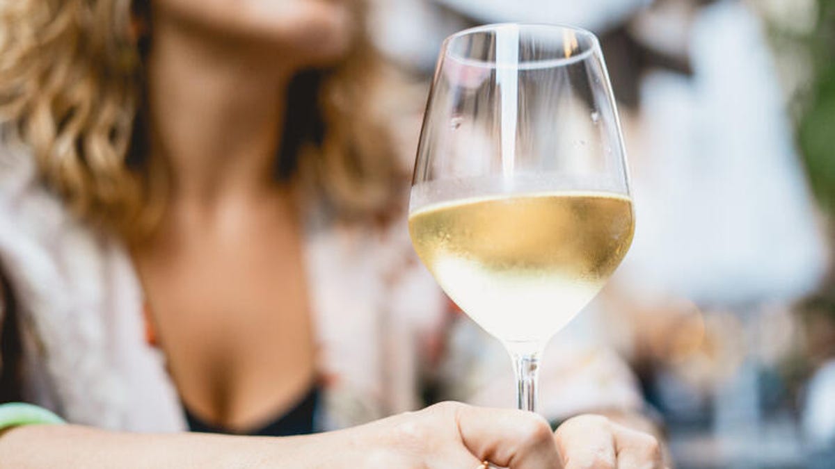 women holding glass of chilled white wine