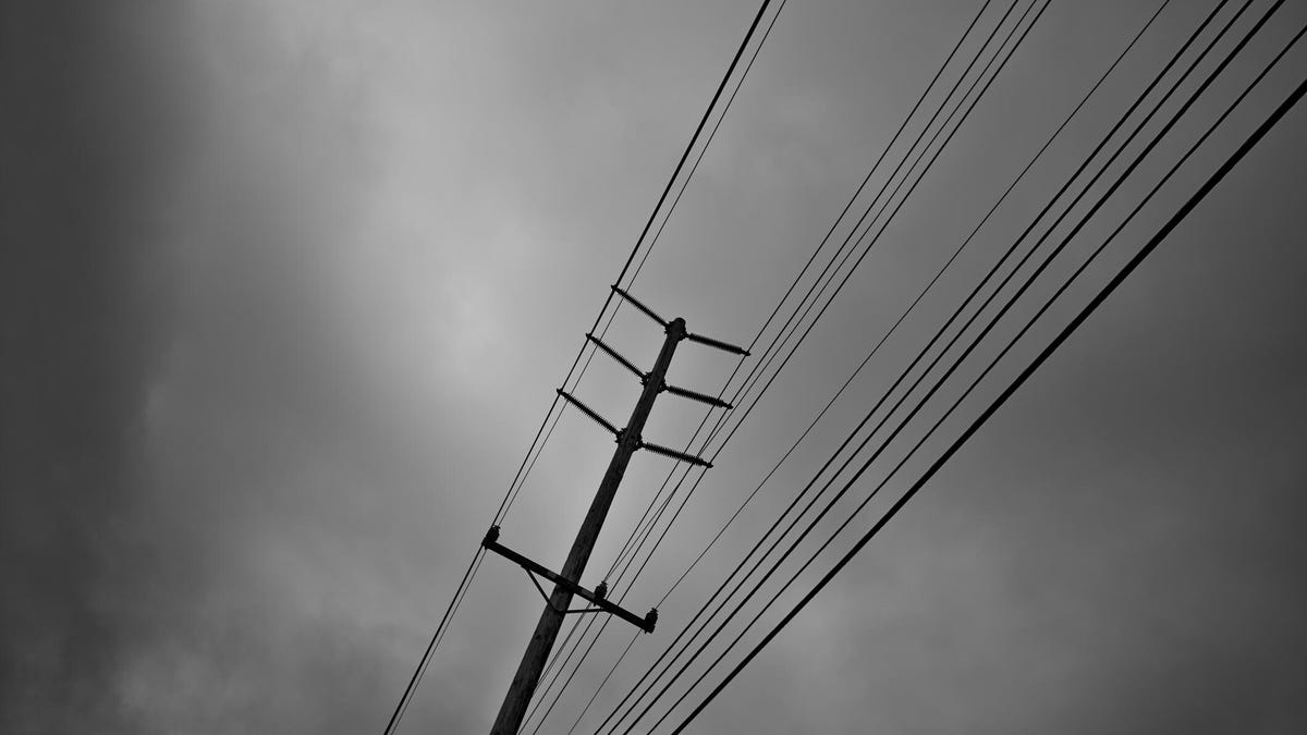 A power pole against a gray sky background.