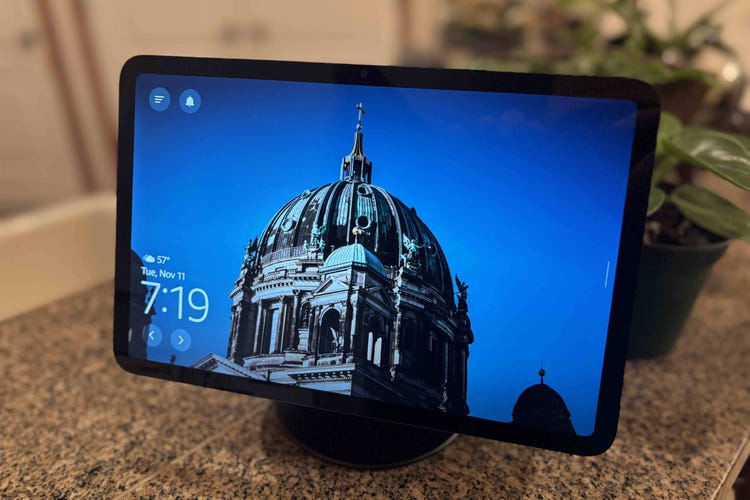 An Echo Show 11 sinces on a granite counter showing blue skies and architecture.