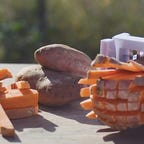 A sweet potato being sliced into fries