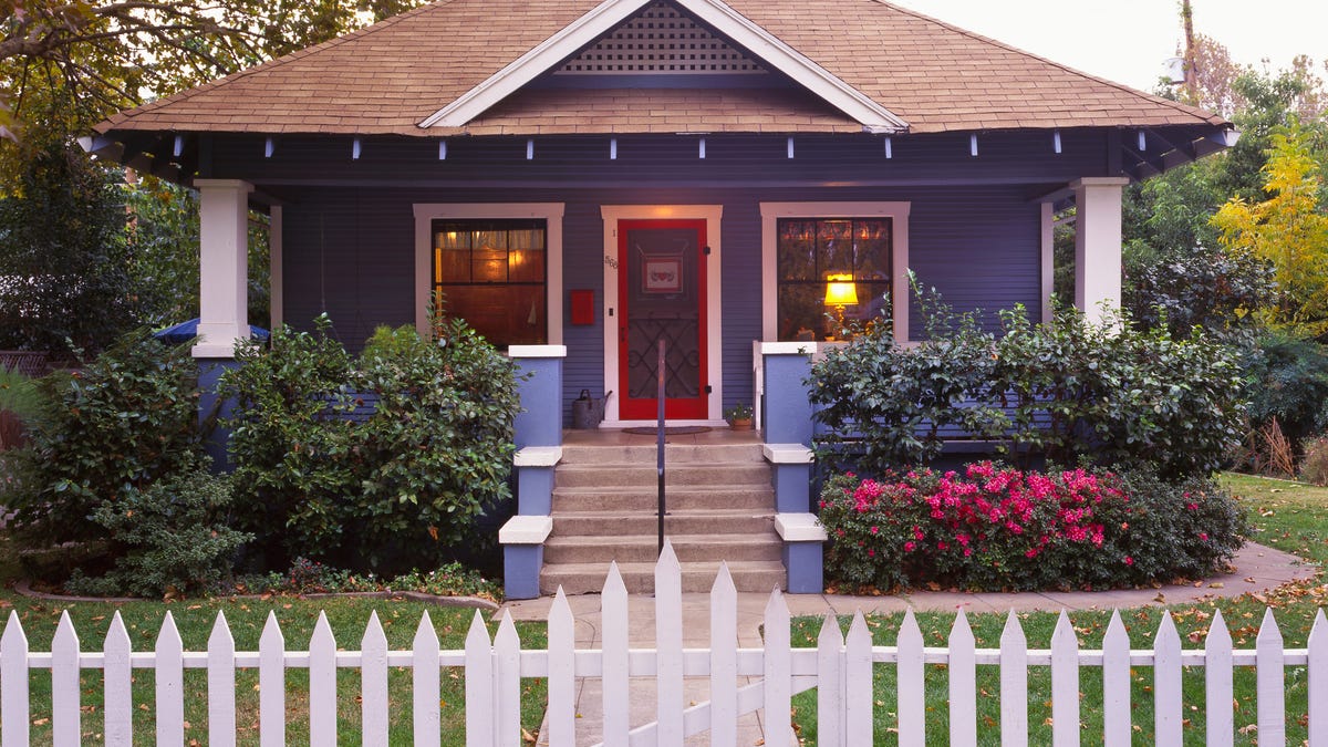 White picket fence around a blue house