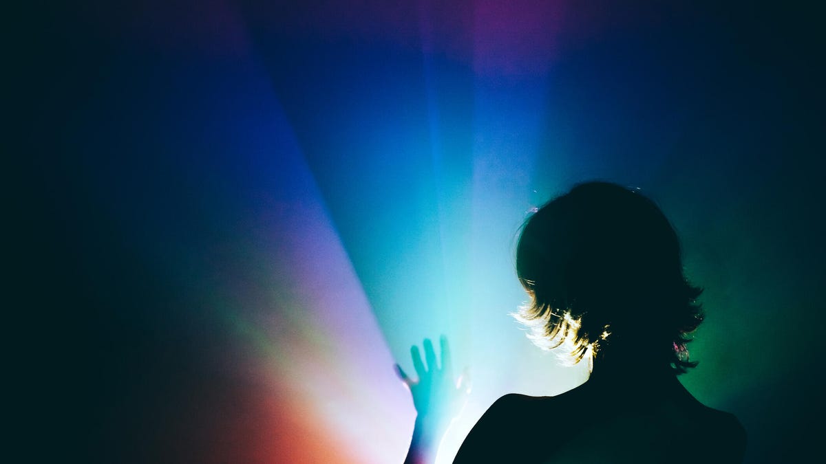 Silhouetted woman against rainbow background
