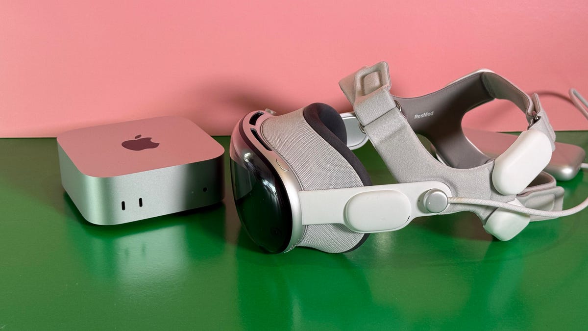 An Apple Vision Pro with a ResMed head strap next to a Mac Mini