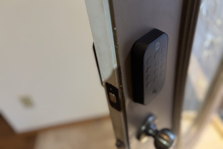 A Yale Assure Lock 2 keypad on an open brown door. 