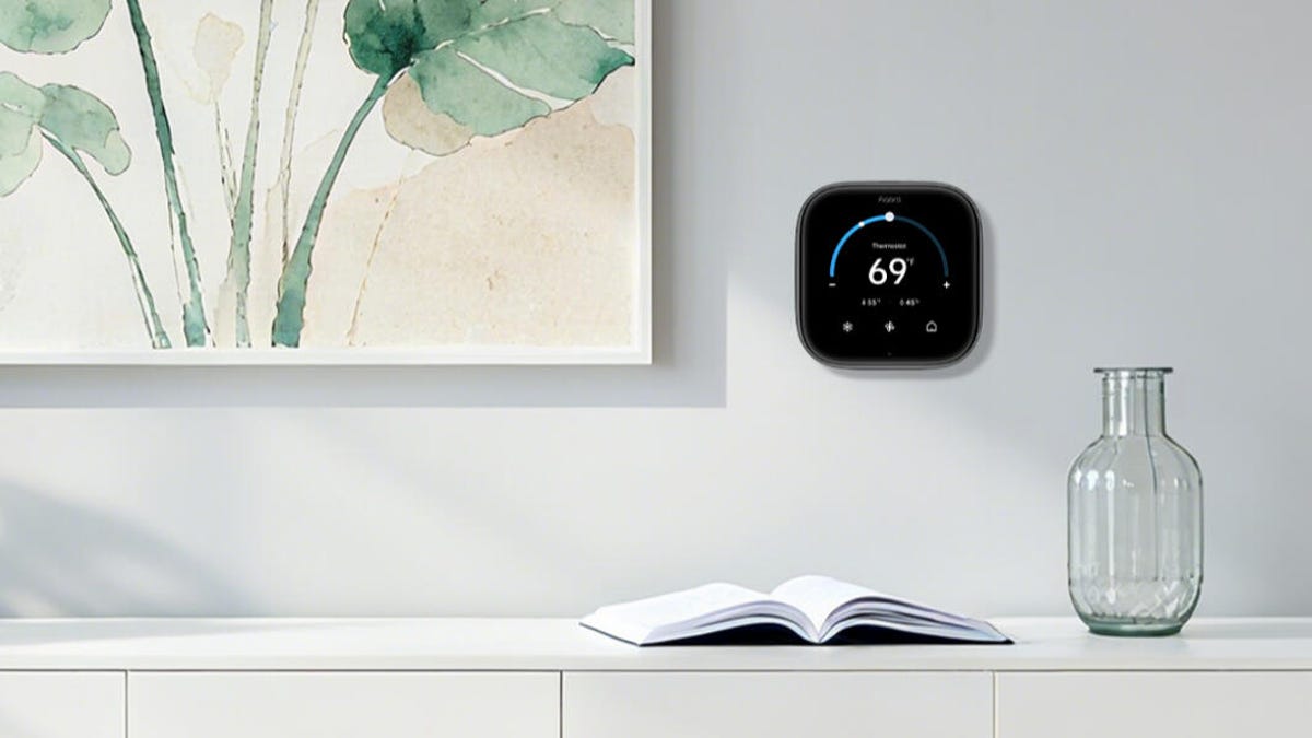 Aqara's new smart thermostat on a white wall by a painting.