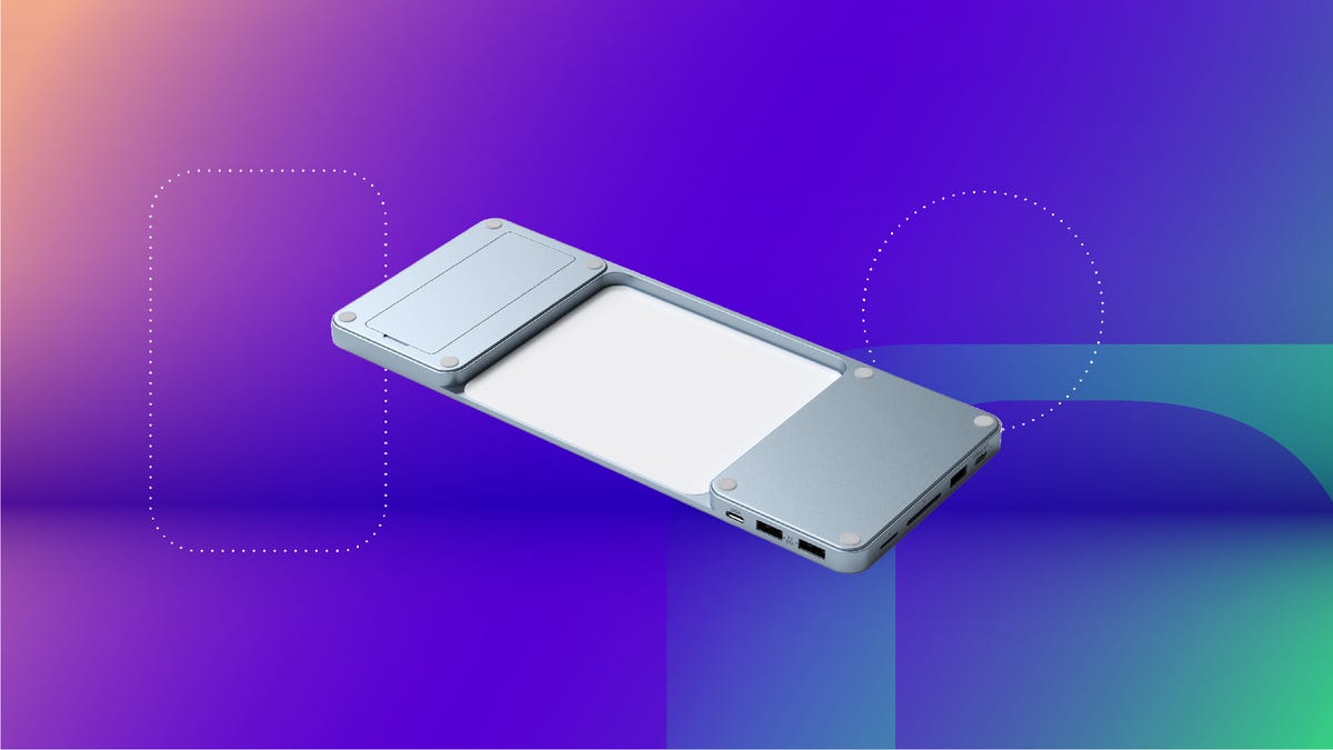 A blue Satechi USB-C dock against an orange, purple and green gradient CNET background.