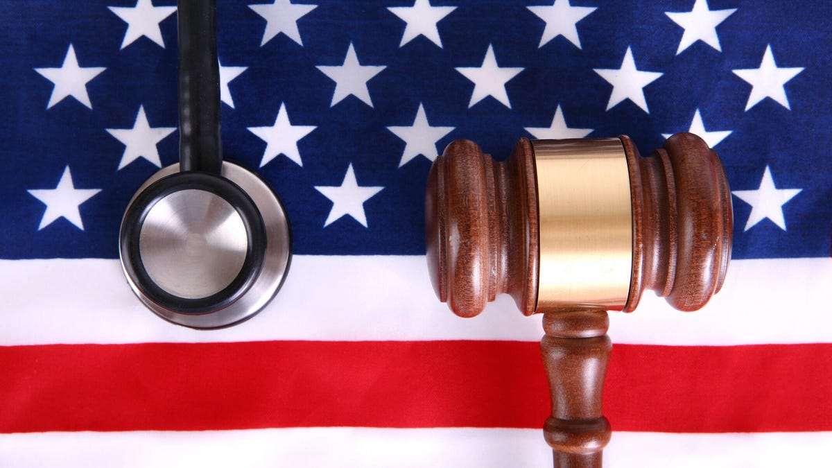 Gavel and stethoscope over US flag