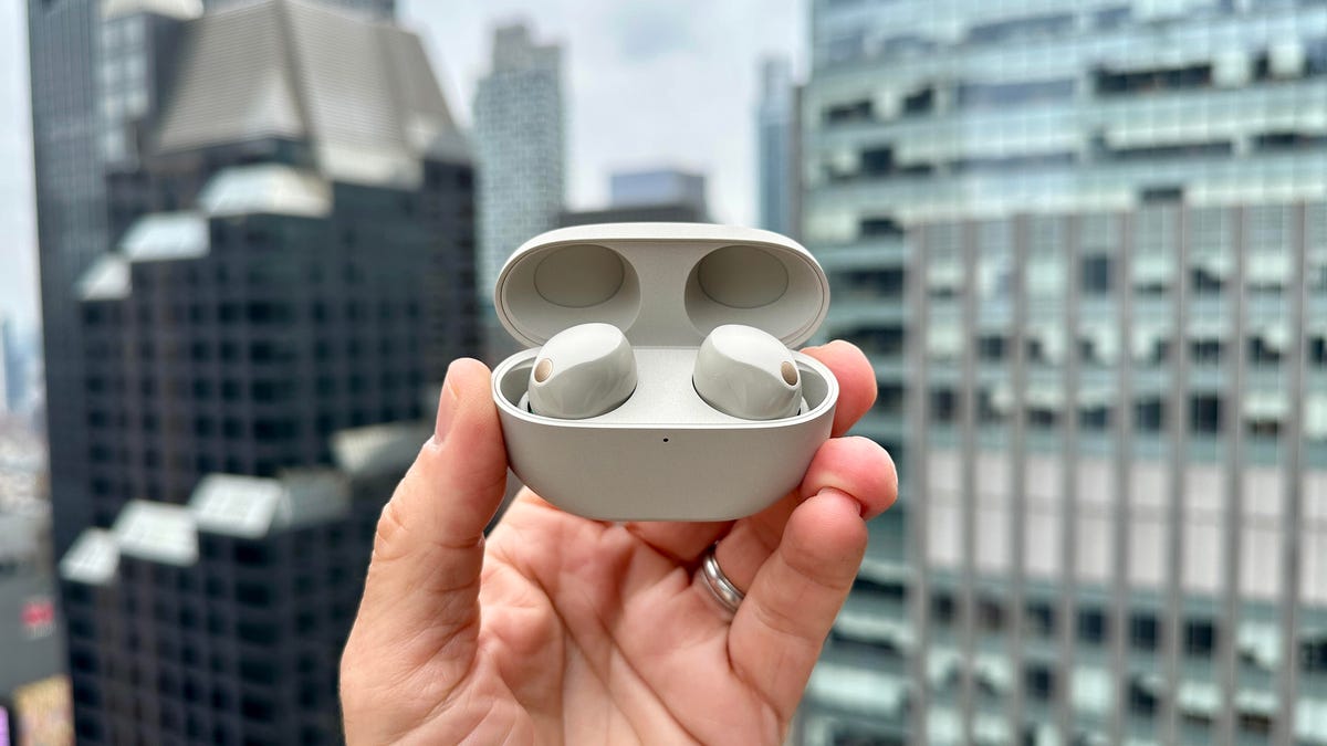 The Sony WF-1000XM5 true wireless earbuds open in front of the New York City skyline.