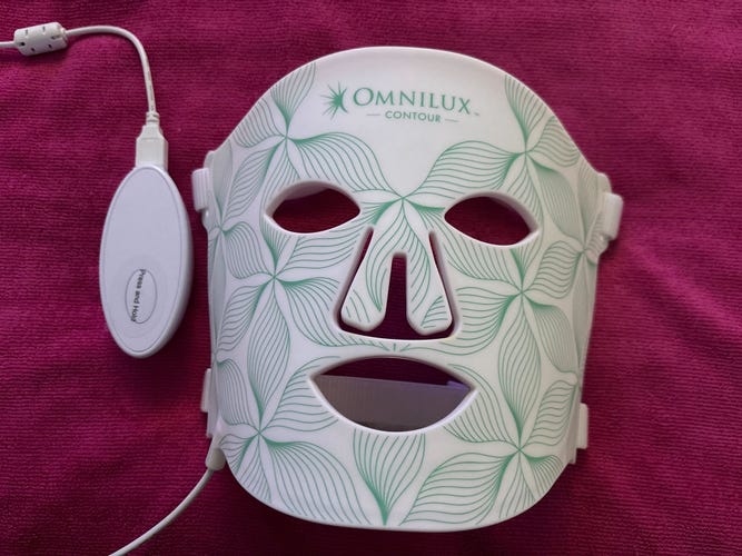Omnilux Contour Face on top of a hot pink fabric.