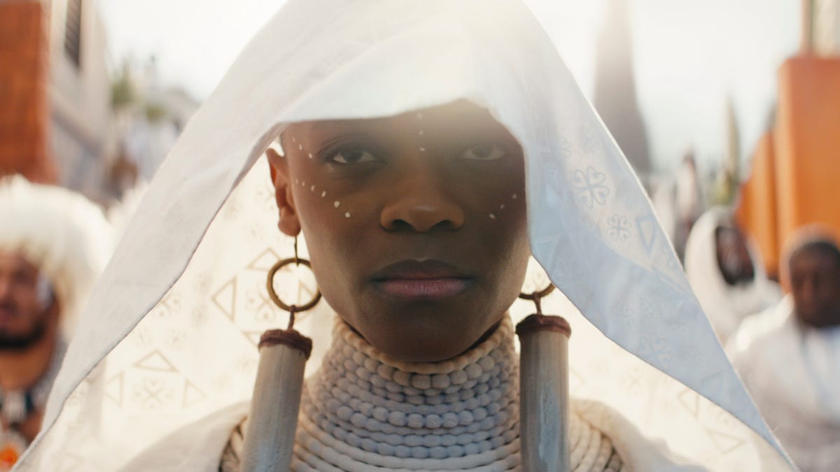 Letitia Wright gazes numbly into the camera in white mourning robes in a scene from Black Panther: Wakanda Forever.