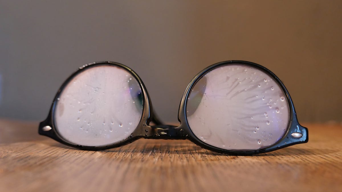 Eyeglasses with foggy lenses on a table.