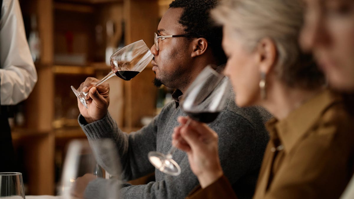 person smelling wine at restaurant table
