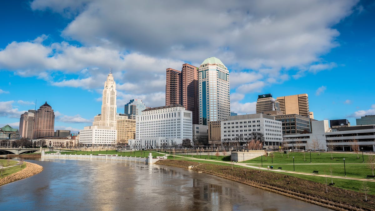 Columbus, Ohio skyline with a blue sky and billowing clouds in the background.