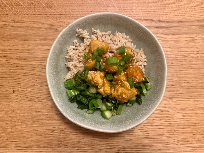 Brown rice, tofu and greens from Purple Carrot in a bowl on a wooden table