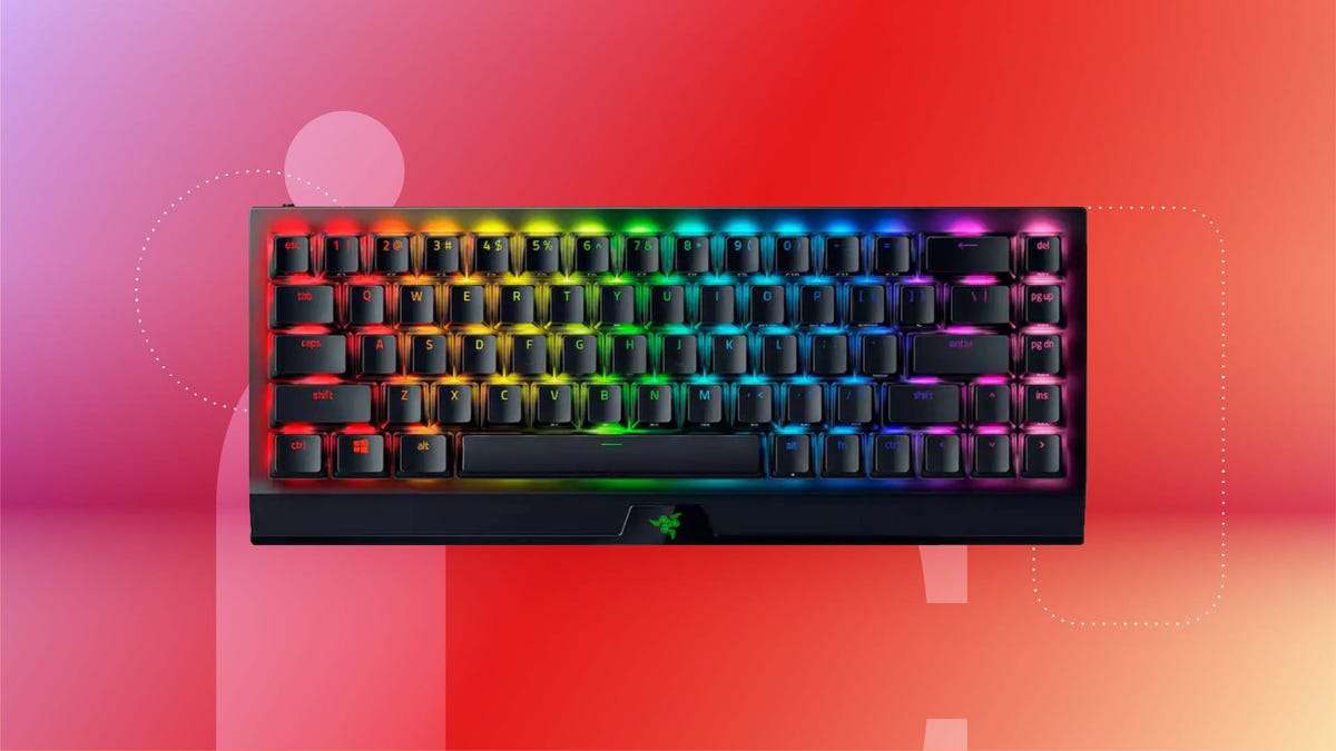 A black keyboard with multicolored lighting against a red gradient CNET background.