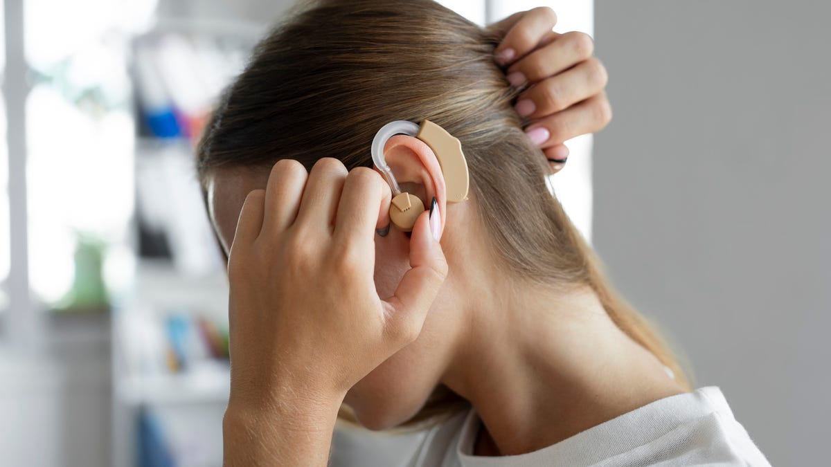 Woman trying on over-the-ear hearing aid