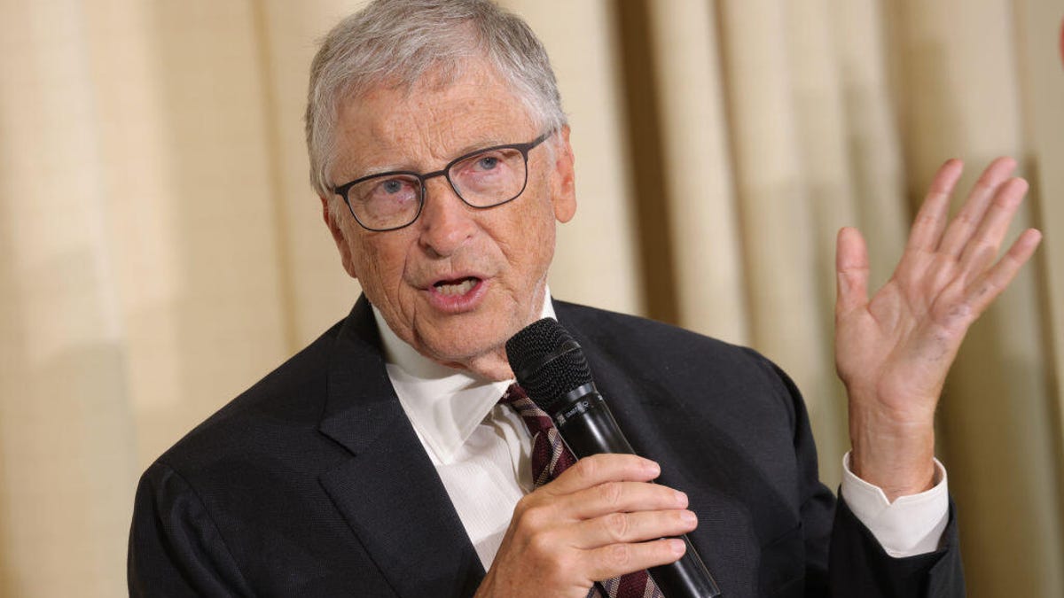 Bill Gates holds a microphone and speaks to an audience in Berlin