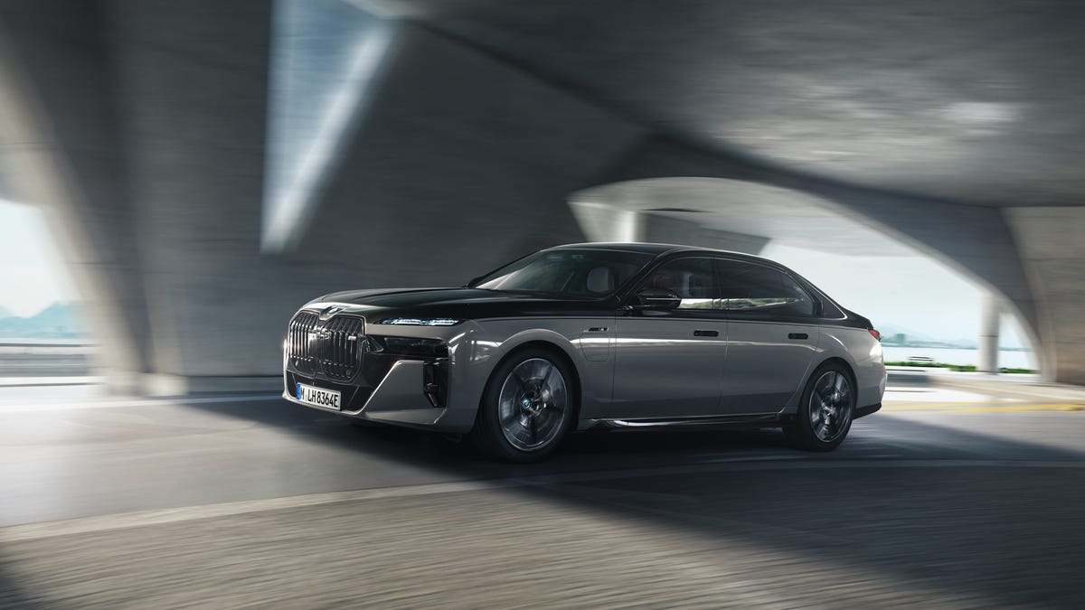 BMW M760e Plug-In Hybrid Sedan driving, from the side