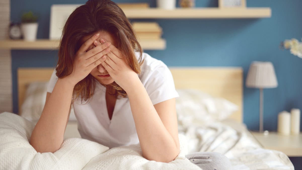 Unhappy woman who is stressed waking up.