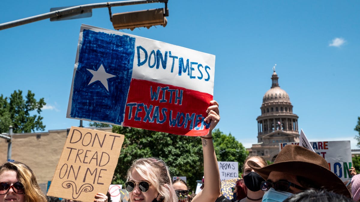 Protesters hold up signs outside the Texas state capitol in May 2021.