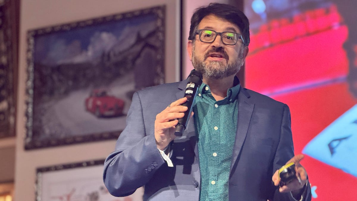 CNET's Scott Stein on a stage talking while wearing Even Realities G2 smart glasses